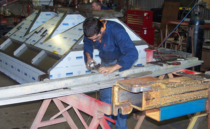 man grinding steel in workshop